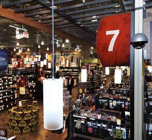 Image of a Dome Camera high above an immense warehouse style wine store with multiple aisles of displayed products and wine.